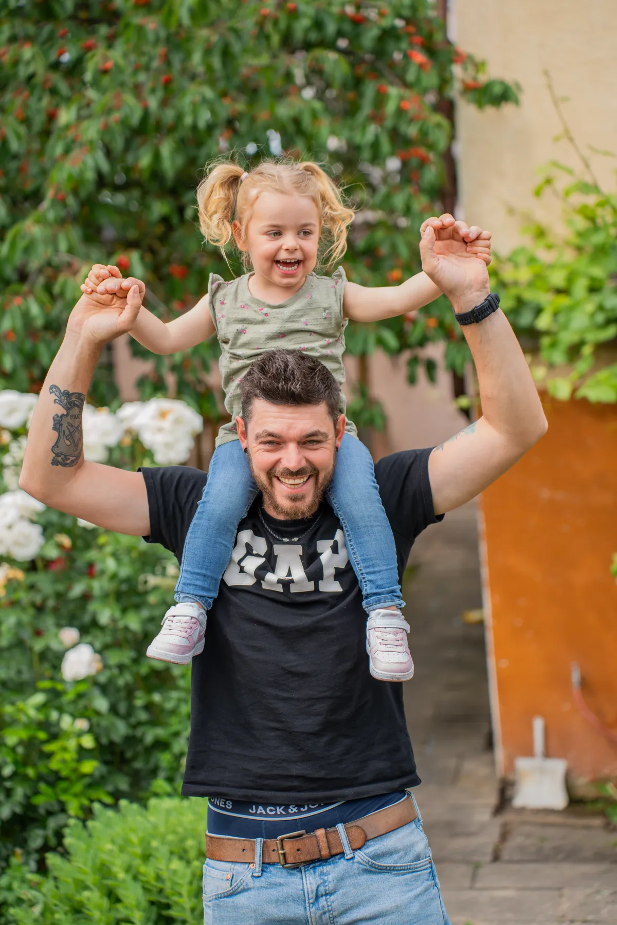 Vater trägt seine Tochter auf den Schultern, die Mutter hält ihre Hand.
