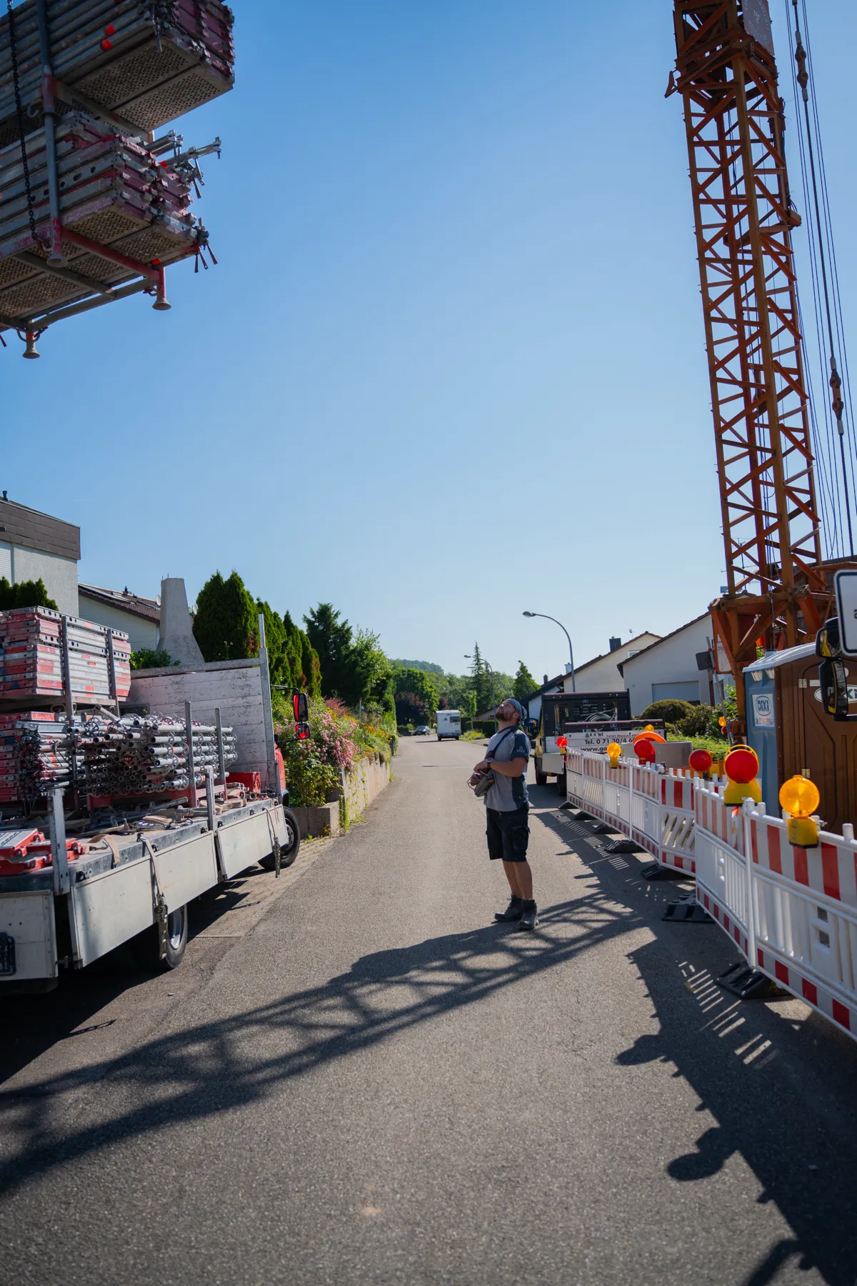 Materialtransport per Kran auf gesperrter Straße.