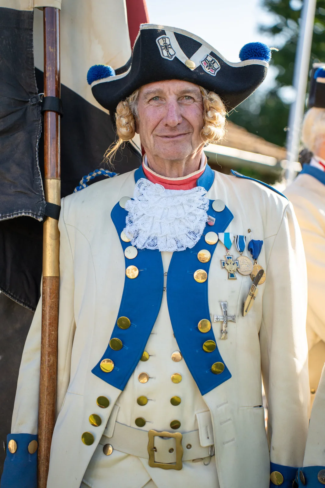 Portrait eines Gardisten in historischer Uniform mit Dreispitz, Spitzenjabot und Orden.