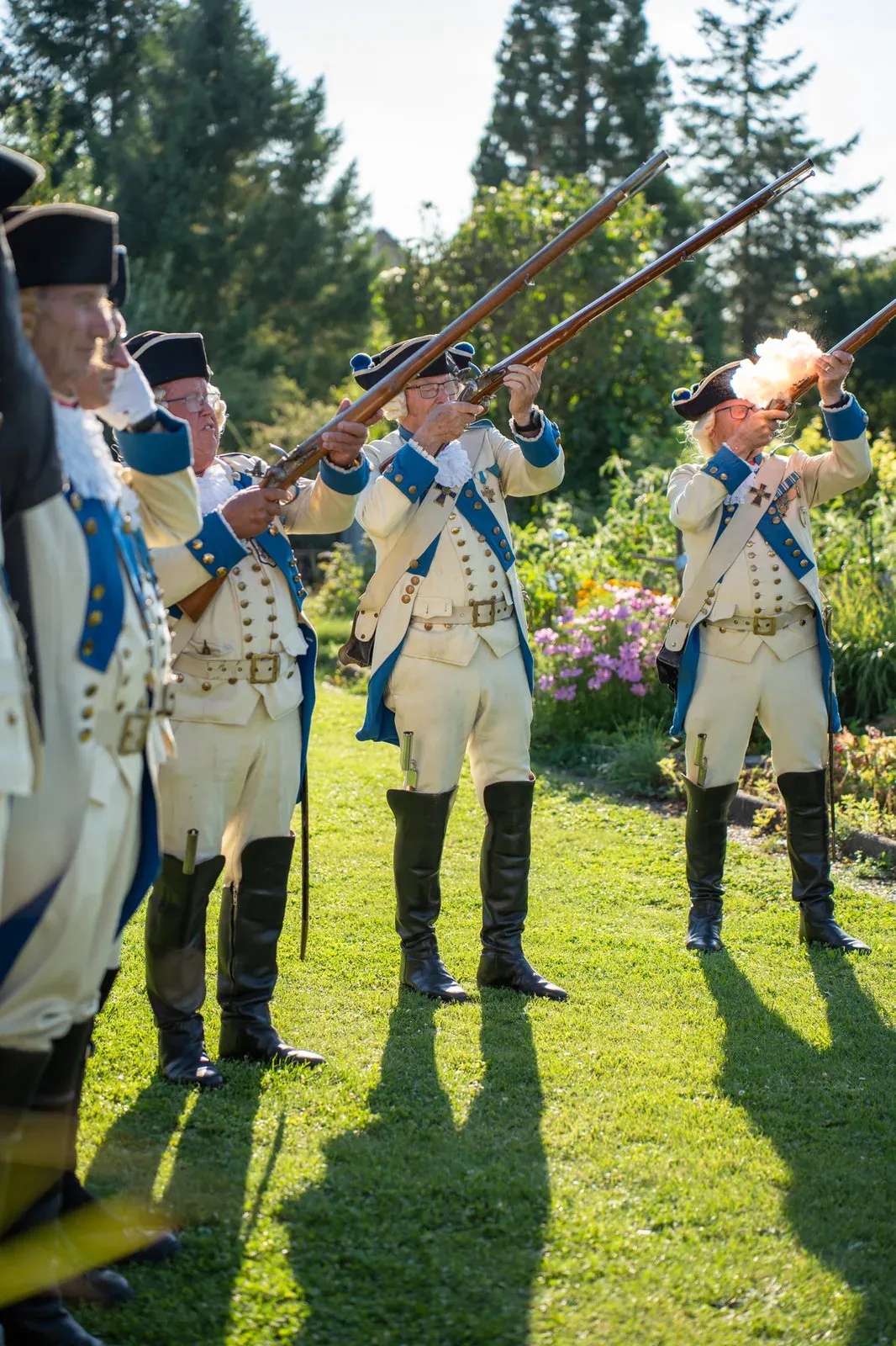 Gardisten legen ihre Musketen an, aus einem Lauf schlägt das Mündungsfeuer.