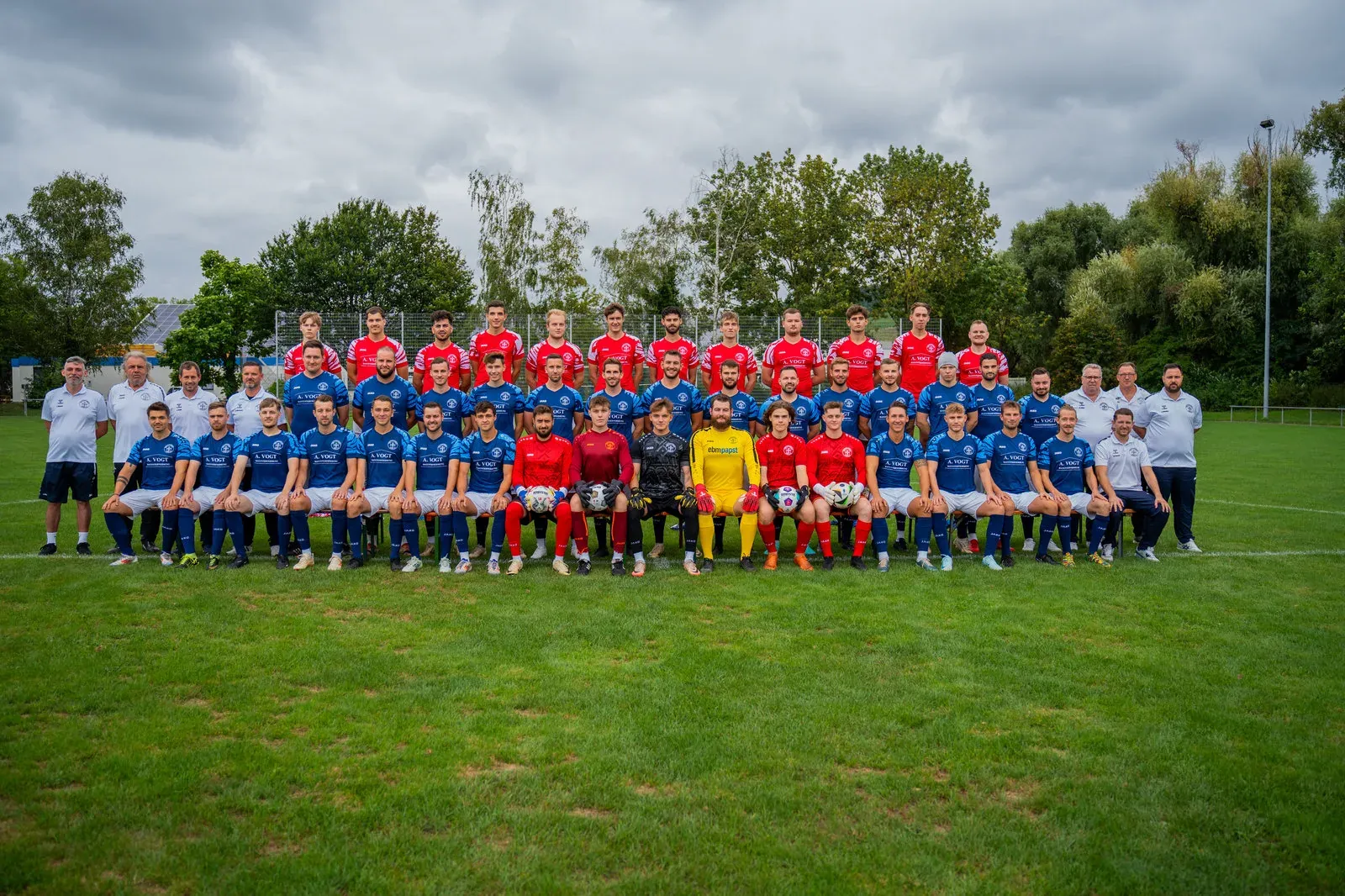 Die Fußballmannschaft posiert in drei Reihen für das Teamfoto der Saison.